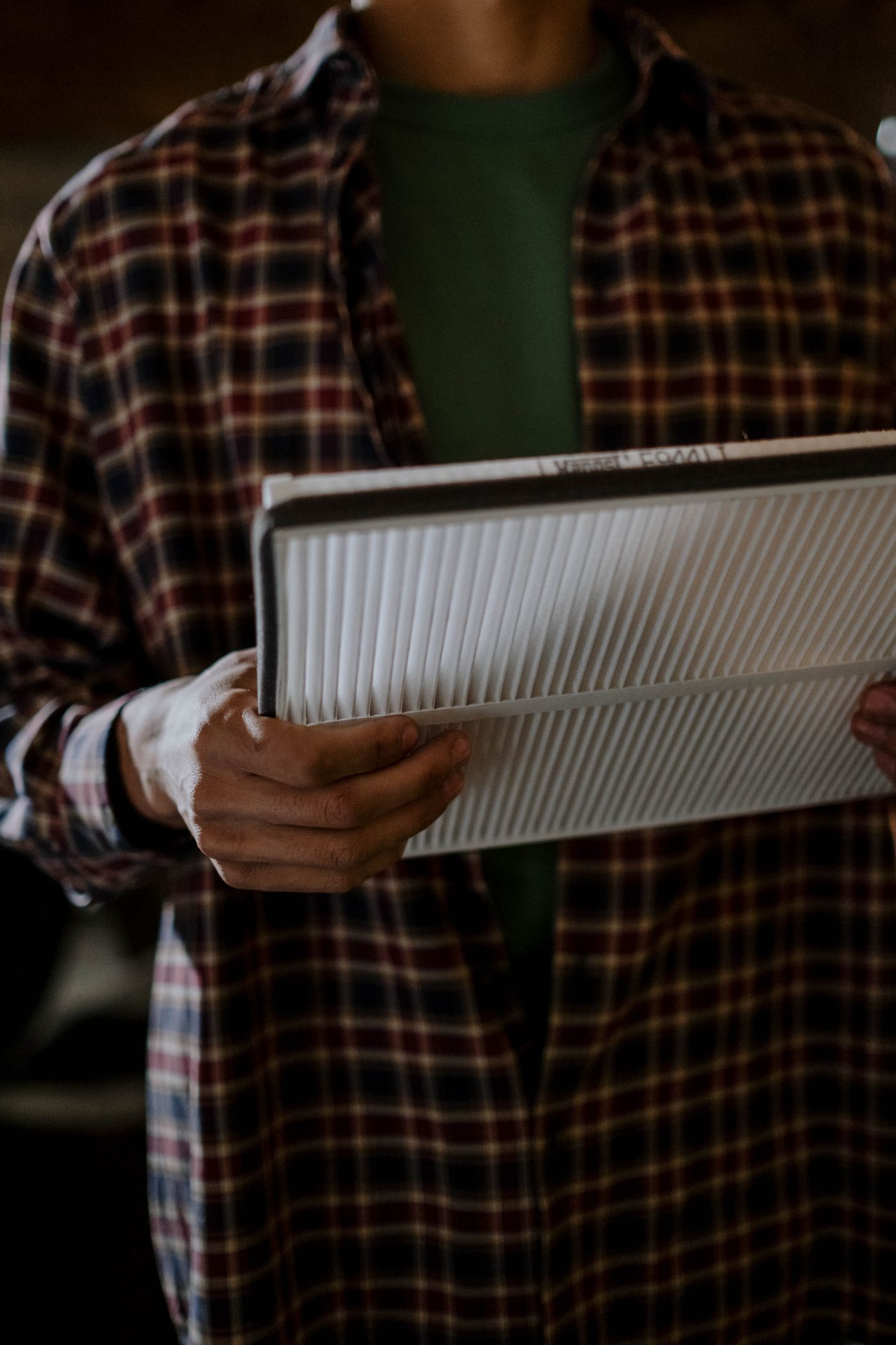 Person holding a rectangular pleated automotive filter.